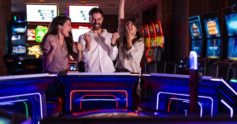 Three cheerful friends enjoy a fun time at a vibrant casino arcade
