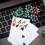 Wooden gavel, money banknotes and playing cards on laptop keyboard