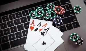 Wooden gavel, money banknotes and playing cards on laptop keyboard