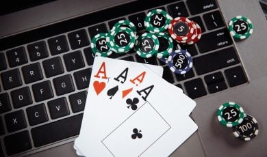 Wooden gavel, money banknotes and playing cards on laptop keyboard