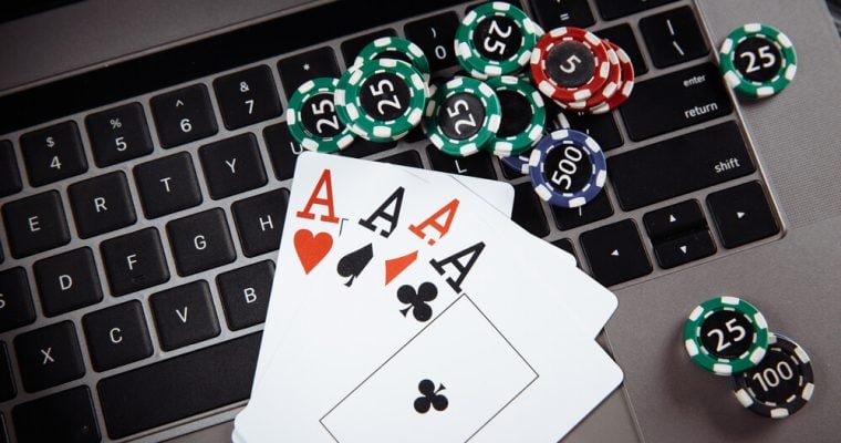 Wooden gavel, money banknotes and playing cards on laptop keyboard