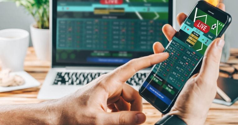 a man making bets using gambling mobile application on his phone