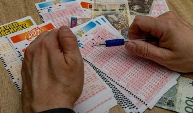 man crosses out 6 digits on a ticket with a pen, lucky numbers and a big cash win in the lottery