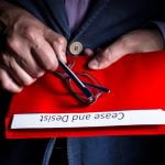 A man opens a letter with cease and desist