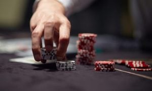 Dealer or croupier shuffles poker cards in a casino on the background of a table, chips
