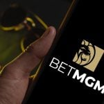 Hand holding a device with the Bet MGM logo