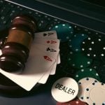 Online casino concept. Gavel, chips and cards on laptop keyboard
