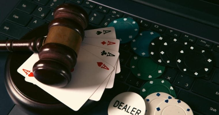 Online casino concept. Gavel, chips and cards on laptop keyboard