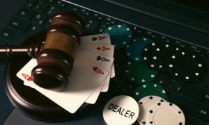 Online casino concept. Gavel, chips and cards on laptop keyboard