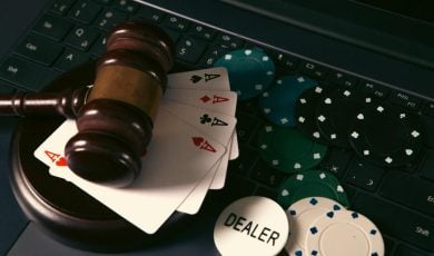 Online casino concept. Gavel, chips and cards on laptop keyboard