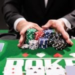 Poker player going all in pushing his chips forward