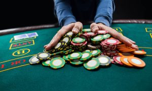 Poker player going all-in pushing his chips forward