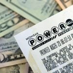 Power Ball lottery ticket lies on many dollar bills close up
