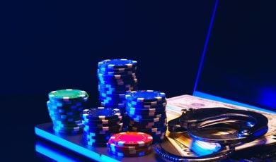 Stacks of Casino Chips and Handcuffs on Laptop Keyboard