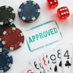 Stamp approved standing near playing cards and chips in casino with dice closeup