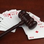 Wooden judge gavel on playing cards deck close up