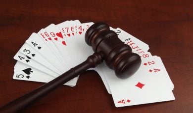 Wooden judge gavel on playing cards deck close up