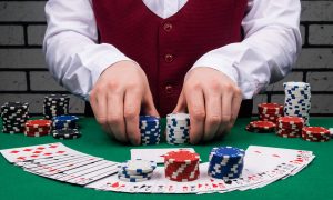 dealer's hands holding stacks of poker chips and cards