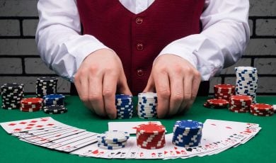 dealer's hands holding stacks of poker chips and cards