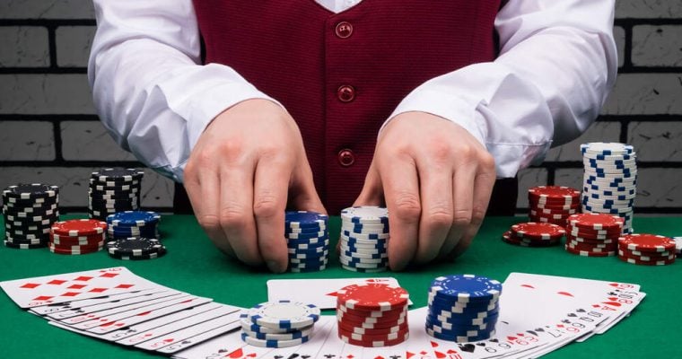 dealer's hands holding stacks of poker chips and cards