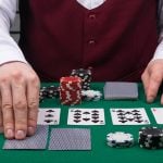 the dealer's hands open cards on the green poker table