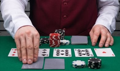the dealer's hands open cards on the green poker table
