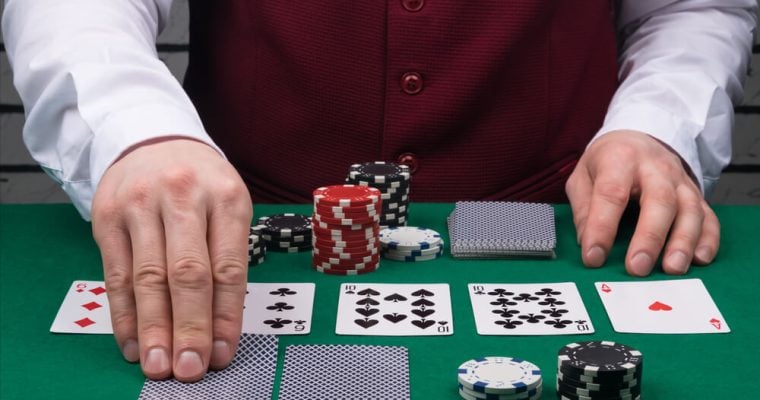 the dealer's hands open cards on the green poker table