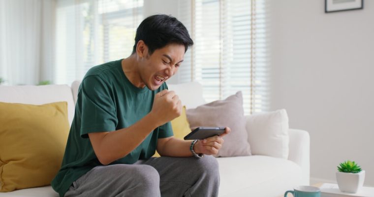 young man smiling and laughing, playing at an online casino